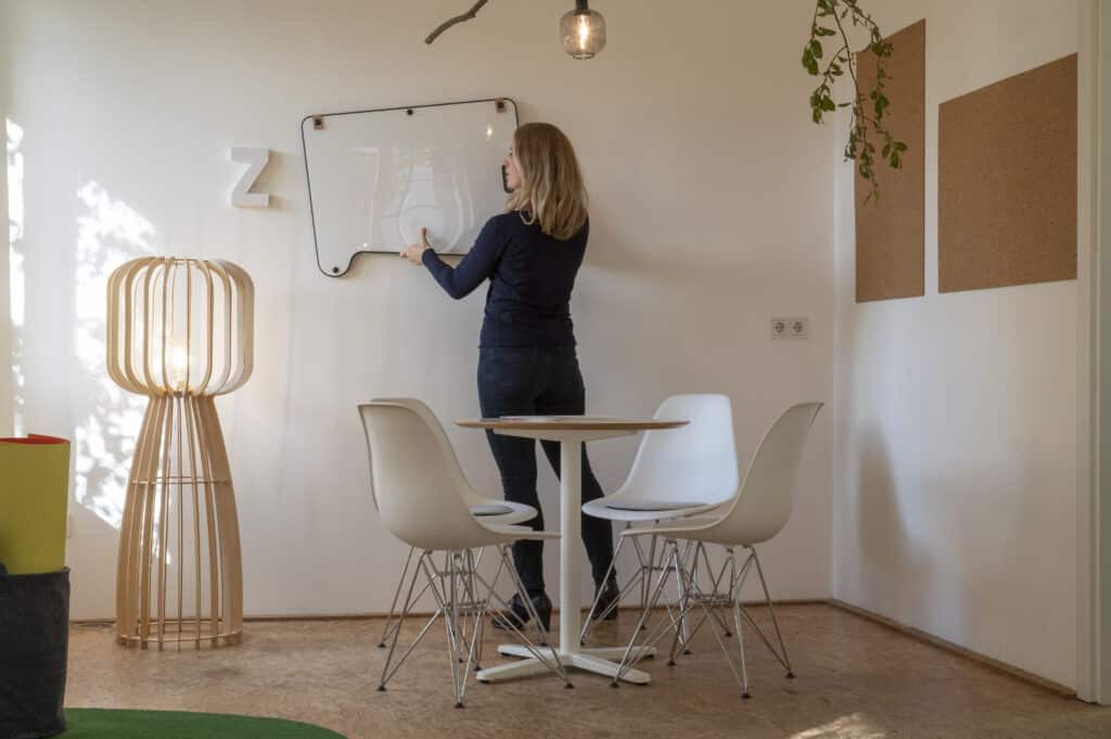 Christiane Wilmes hängt Whiteboard auf